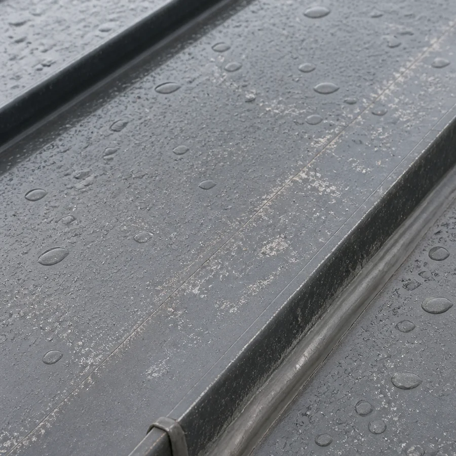 Weathered coated metal roof panel with water beads